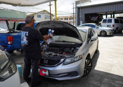 Chikʻs Auto Air - Staff adding AC coolant to car